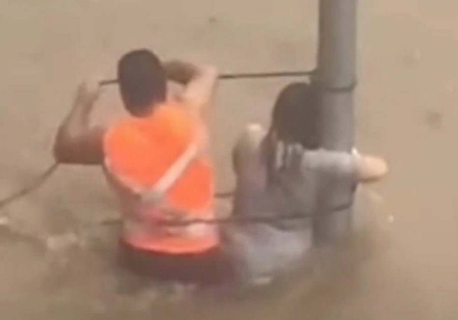 Mulher é amarrada para não ser levada por enxurrada