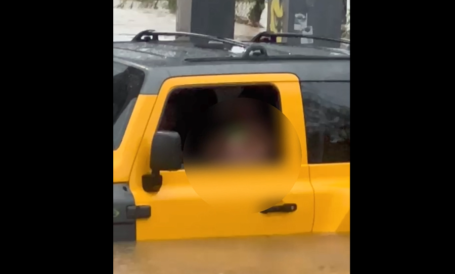 Criança se protege no colo do pai, enquanto família fica ilhada em chuva