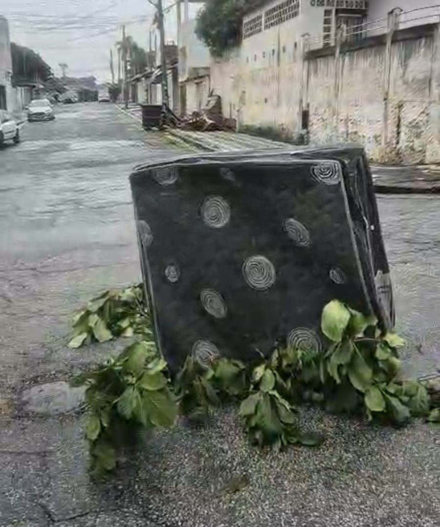Moradores sinalizam cratera no meio da rua com colchão e galhos